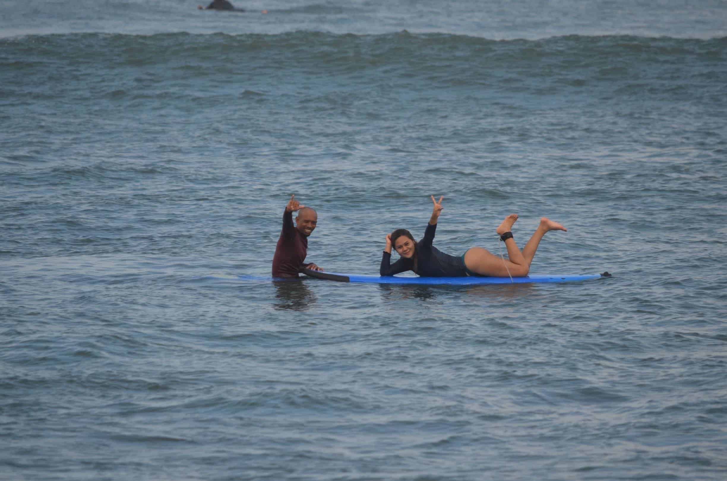 Agus coaching a smiling surf student in the water in Canggu