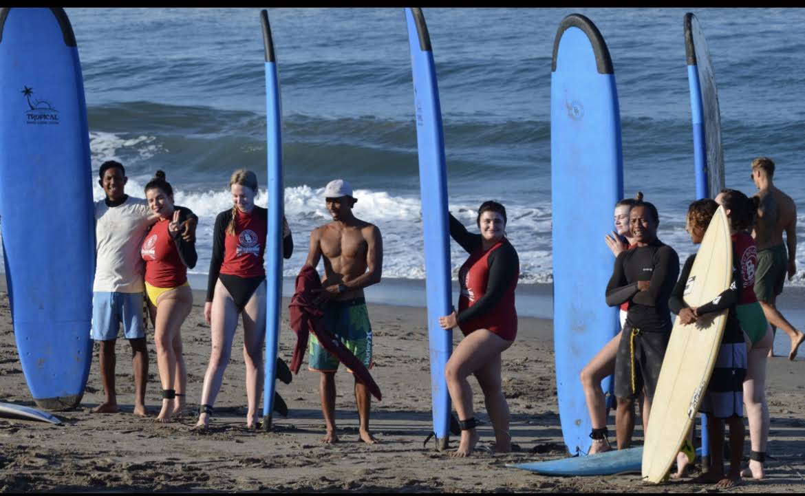 Surf students and instructors with boards on the beach in Canggu