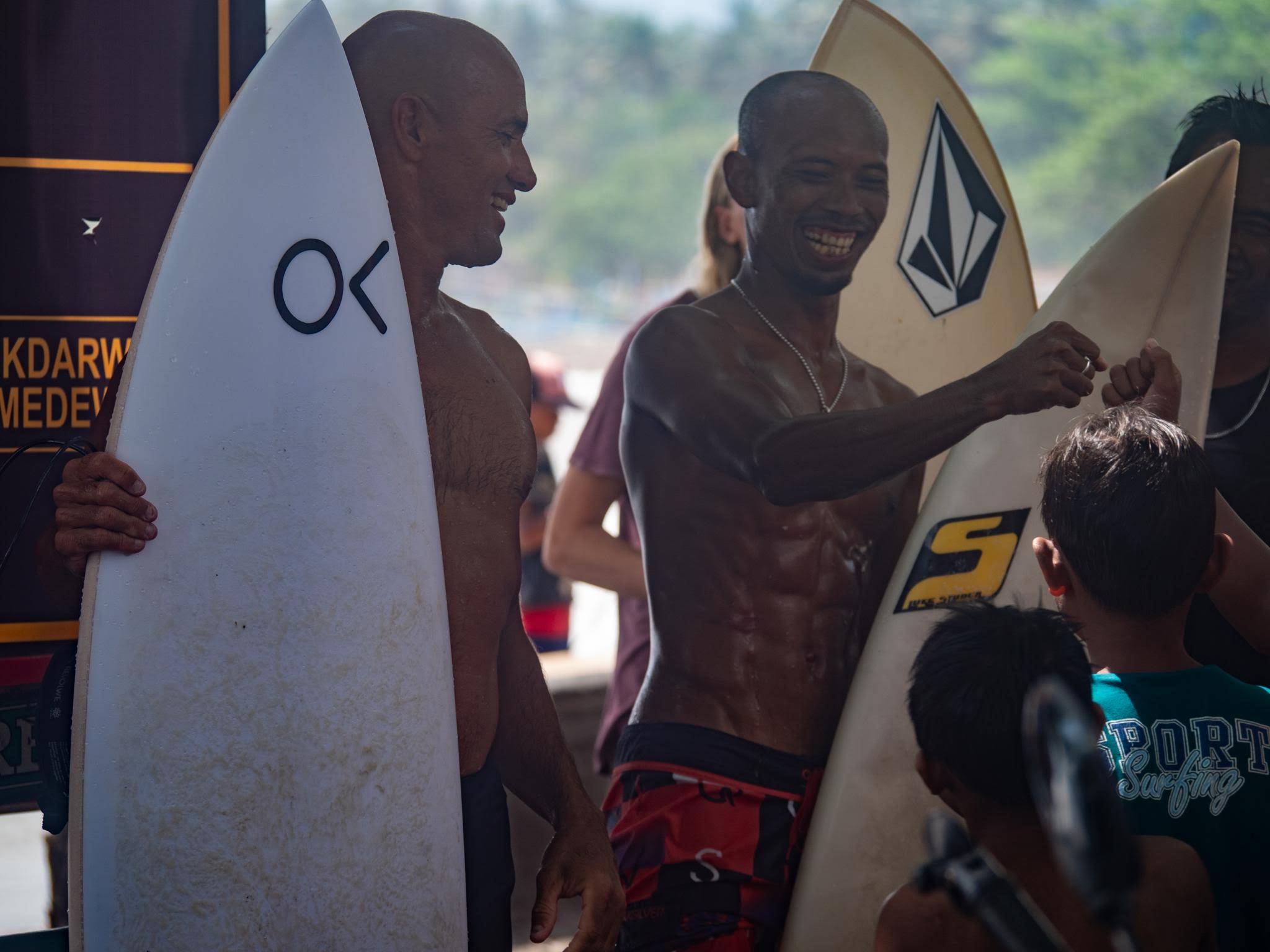 Agus smiling with surfers and boards in Medewi